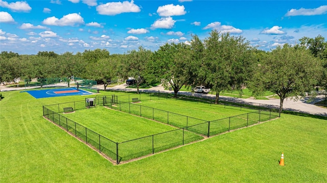 surrounding community with basketball court and a lawn