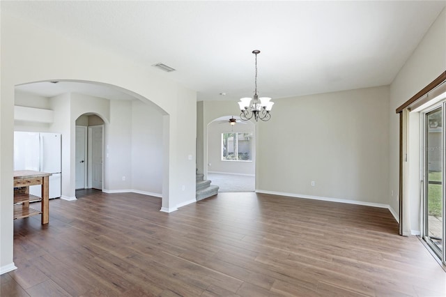 unfurnished room with a notable chandelier and wood-type flooring