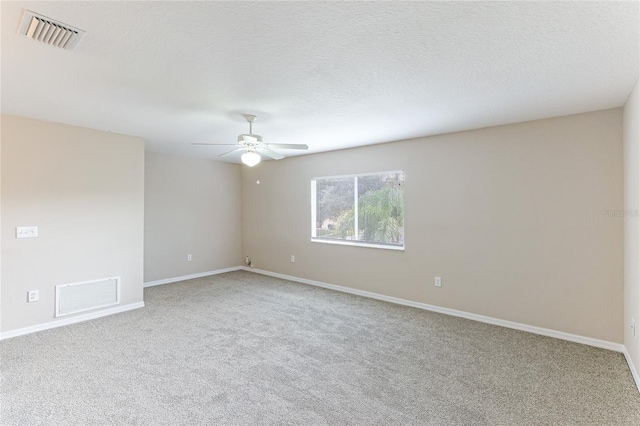 unfurnished room featuring ceiling fan, light colored carpet, and a textured ceiling