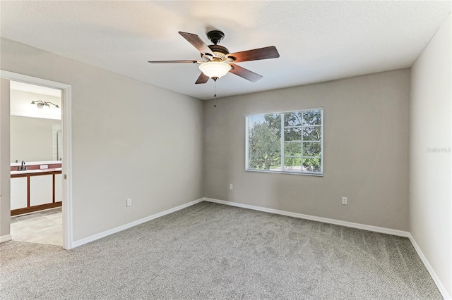 unfurnished room with a textured ceiling, light carpet, and ceiling fan