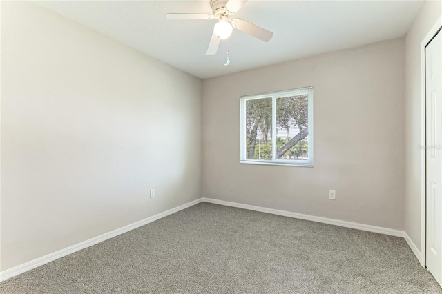 carpeted spare room with ceiling fan