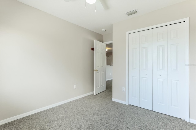 unfurnished bedroom featuring ceiling fan, a closet, and carpet