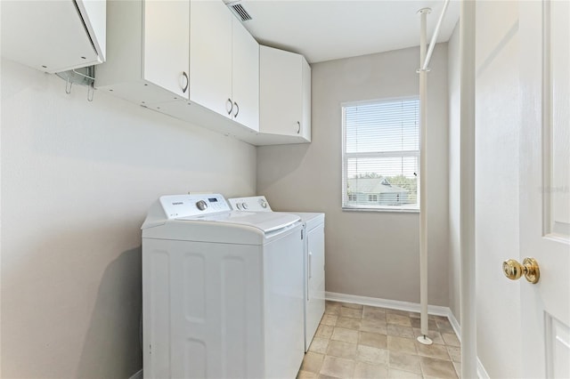 laundry room featuring washer and clothes dryer and cabinets