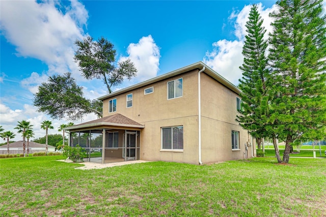 rear view of property with a sunroom and a lawn