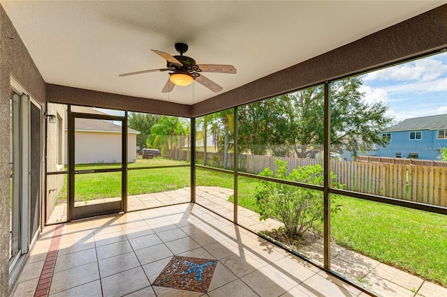 unfurnished sunroom featuring ceiling fan