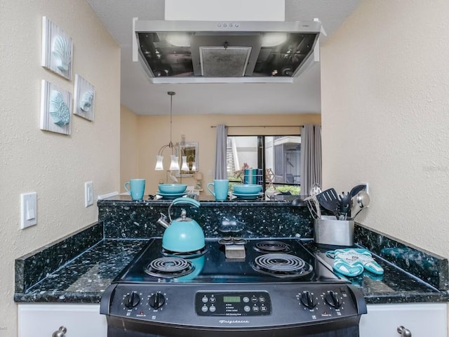 kitchen featuring black electric range, decorative light fixtures, extractor fan, and white cabinetry