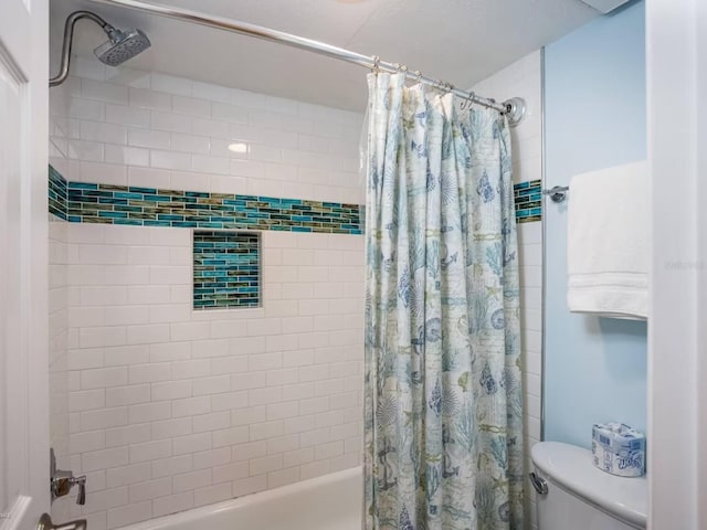 bathroom featuring shower / bath combo and toilet