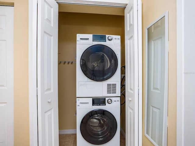 6157 Midnight Pass Rd Unit A51, Sarasota, FL 34242 - clothes washing area featuring estacked washer and dryer, tile patterned floors, and baseboards