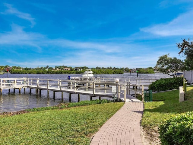 view of dock with a water view and a yard