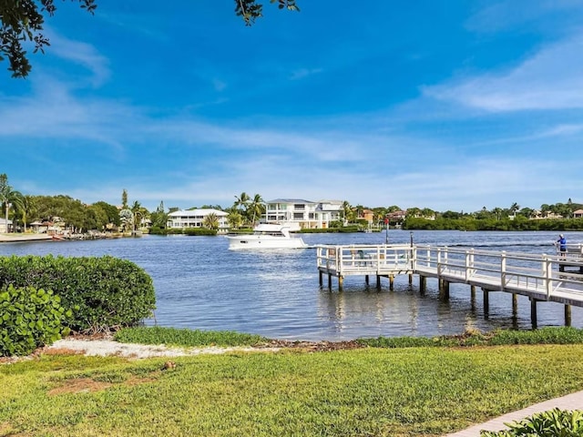 view of dock with a water view and a yard