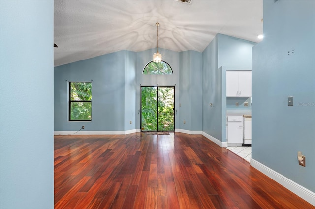 unfurnished room featuring a textured ceiling, lofted ceiling, and hardwood / wood-style floors