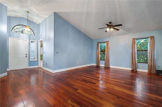 foyer with a wealth of natural light, a textured ceiling, and dark hardwood / wood-style flooring