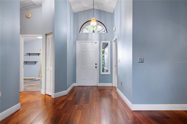 entryway featuring high vaulted ceiling, a chandelier, and dark hardwood / wood-style floors