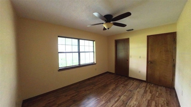 unfurnished bedroom with dark wood-type flooring and ceiling fan