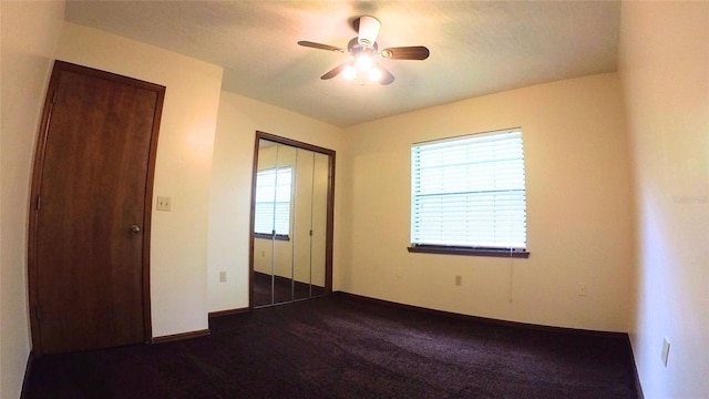 unfurnished bedroom featuring a closet, ceiling fan, and dark colored carpet