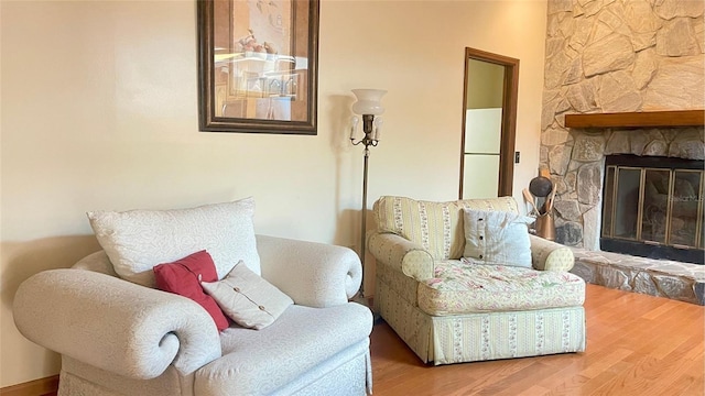 living area with a fireplace and wood-type flooring