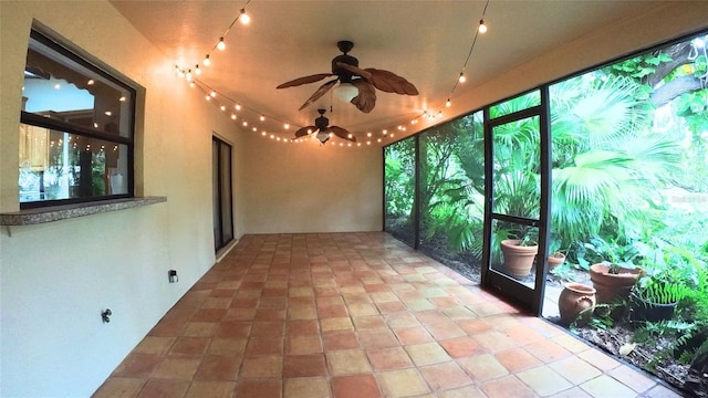 unfurnished sunroom with ceiling fan