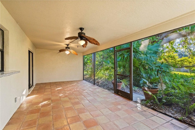 unfurnished sunroom featuring a ceiling fan