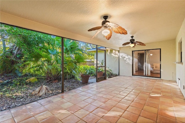 unfurnished sunroom featuring a ceiling fan