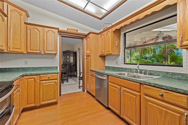 kitchen featuring a sink, vaulted ceiling, range with electric stovetop, stainless steel dishwasher, and dark countertops