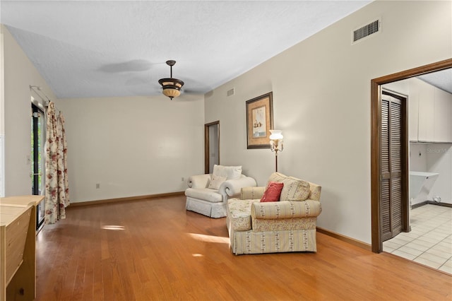 living room featuring visible vents, baseboards, and wood finished floors