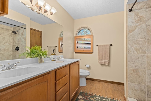 bathroom with a sink, toilet, and a tile shower