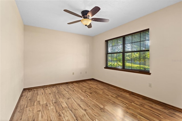 empty room featuring a ceiling fan, wood finished floors, and baseboards