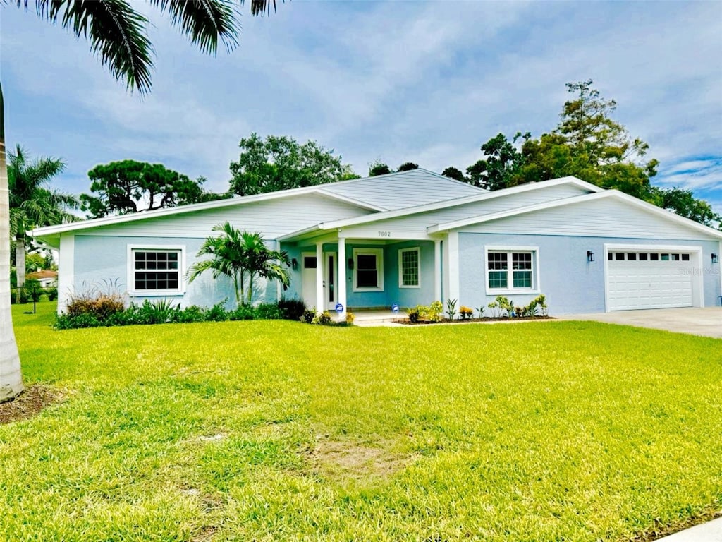 single story home featuring a garage, covered porch, and a front lawn