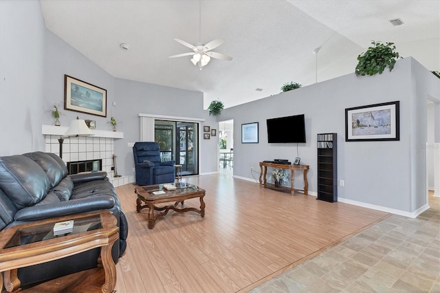 living room with light hardwood / wood-style floors, lofted ceiling, a fireplace, and ceiling fan