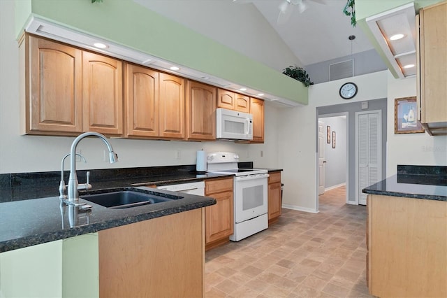 kitchen featuring vaulted ceiling, white appliances, ceiling fan, dark stone counters, and sink