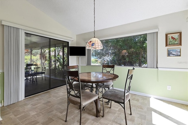 dining space featuring lofted ceiling and a textured ceiling