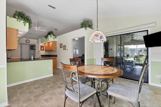 dining room with ceiling fan, sink, and vaulted ceiling