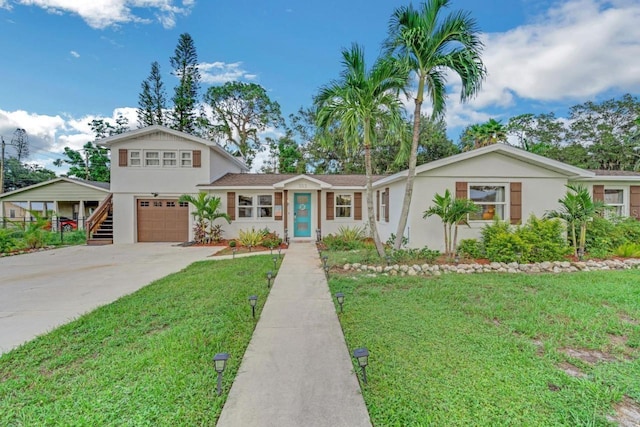 view of front facade featuring stucco siding, concrete driveway, and a front yard