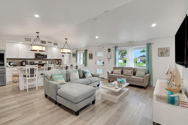 living room with recessed lighting, lofted ceiling, visible vents, and light wood-type flooring