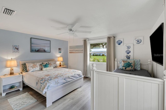 bedroom featuring visible vents, a ceiling fan, and wood finished floors