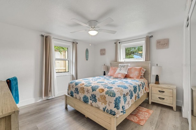 bedroom featuring ceiling fan, a textured ceiling, and light hardwood / wood-style flooring