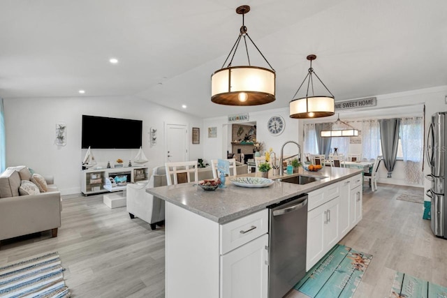 kitchen with white cabinetry, a sink, light wood-type flooring, and appliances with stainless steel finishes