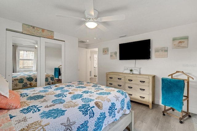 bedroom featuring a closet, visible vents, light wood-style flooring, and a ceiling fan