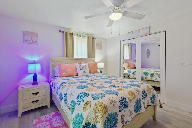 bedroom with a ceiling fan, baseboards, and wood finished floors
