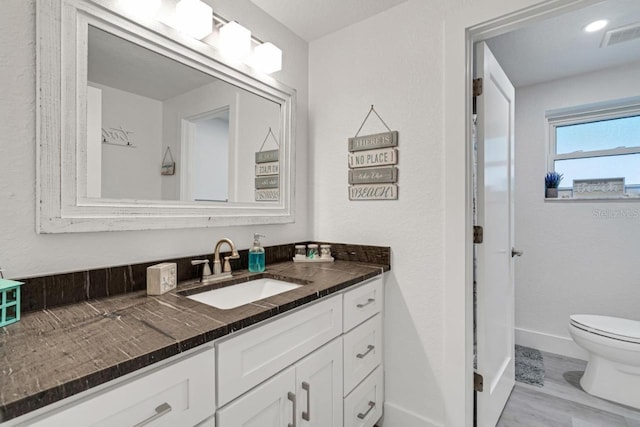 bathroom featuring vanity, toilet, and wood-type flooring