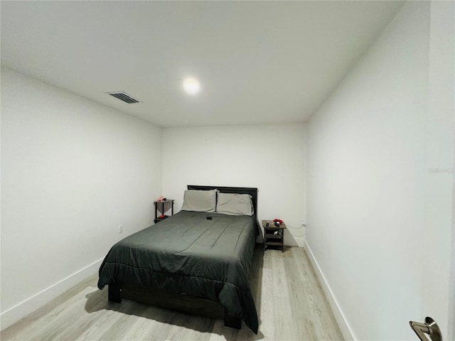bedroom with baseboards, light wood-style flooring, and visible vents