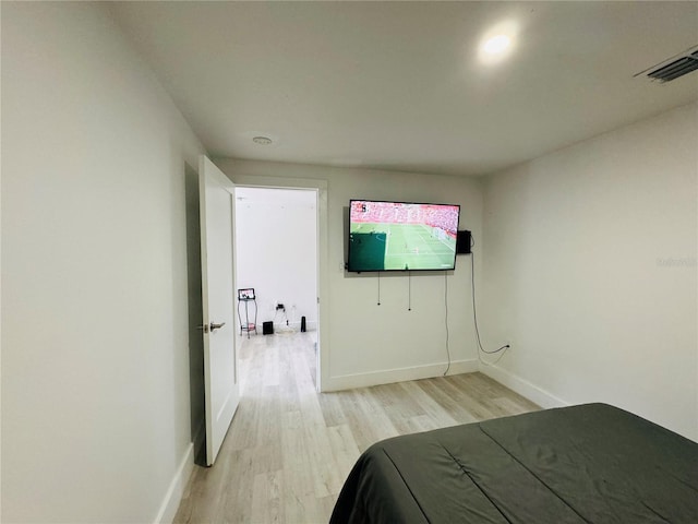 bedroom featuring baseboards, visible vents, and light wood finished floors