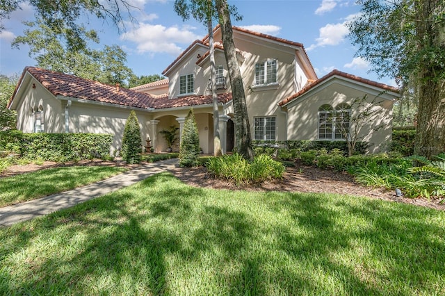 mediterranean / spanish home with a front lawn