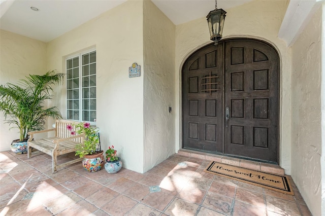 view of exterior entry featuring covered porch