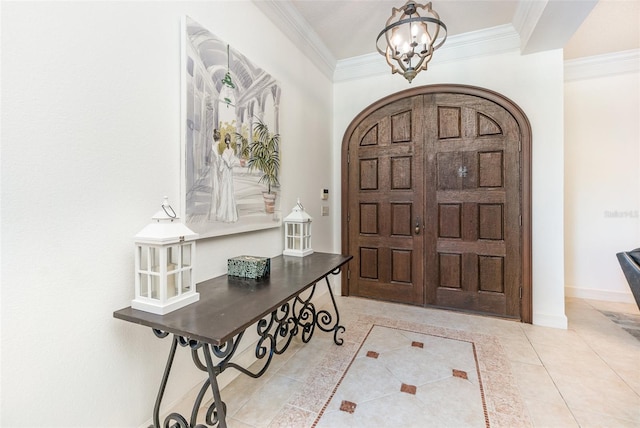 foyer featuring an inviting chandelier, light tile patterned floors, and ornamental molding