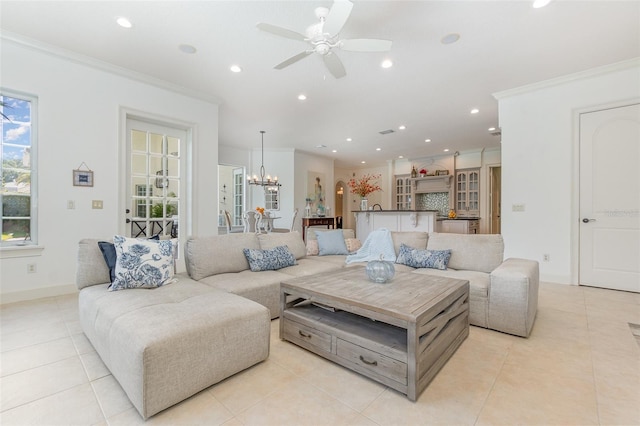 living room featuring ceiling fan with notable chandelier, light tile patterned floors, and crown molding