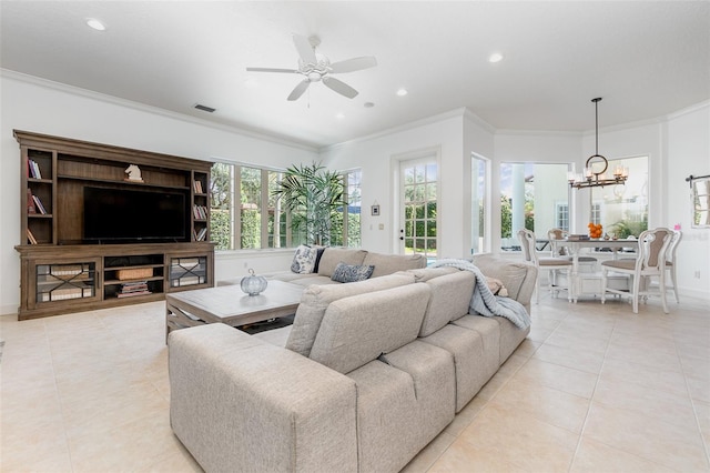 tiled living room with ceiling fan with notable chandelier and crown molding