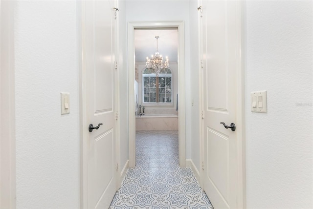 hallway with an inviting chandelier