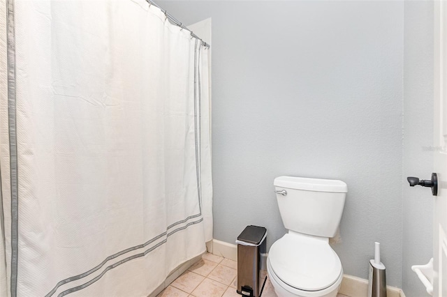 bathroom featuring curtained shower, toilet, and tile patterned floors