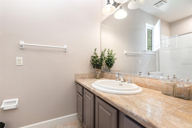 bathroom featuring tile patterned flooring, walk in shower, vanity, and toilet